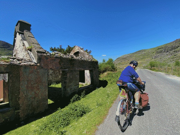 Travis and Ruby standing in front of a castle in County Kerry, Ireland on their honeymoon bike tour